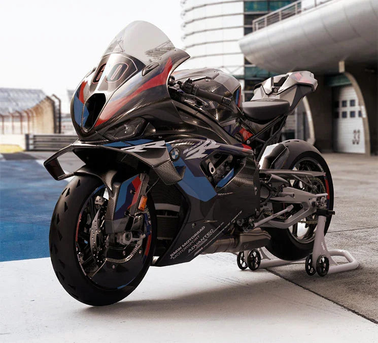 Black BMW M 1000 RR 2023 sport motorcycle with red and blue accents parked on a racetrack pit lane