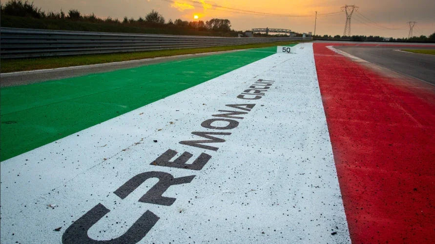 Cremona Circuit race track curb painted green, white, and red with sunset and power lines in background