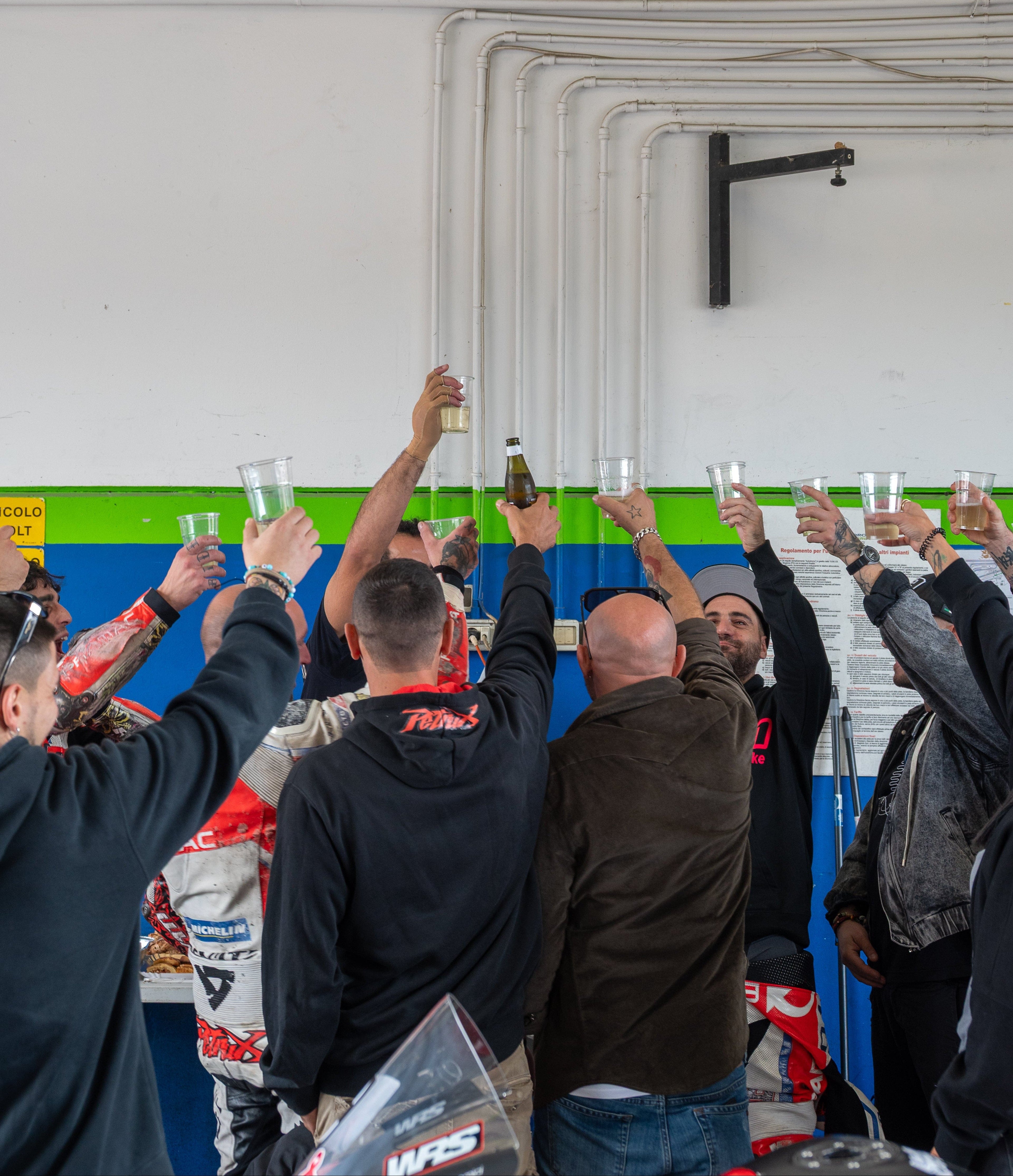 Piloti e staff BMR Noleggi brindano nel box durante una giornata di track day in circuito dopo il noleggio moto in pista