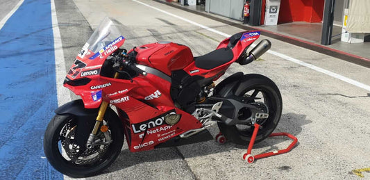 Ducati Panigale V4S 2025 replica MotoGP parcheggiata nella pit lane, livrea ufficiale Lenovo e dettagli racing